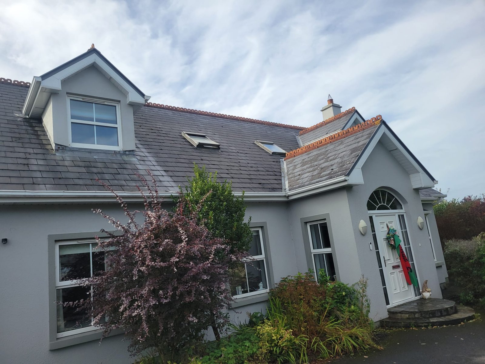 Front of the house with cleaned white roofline trim and dormer fascia